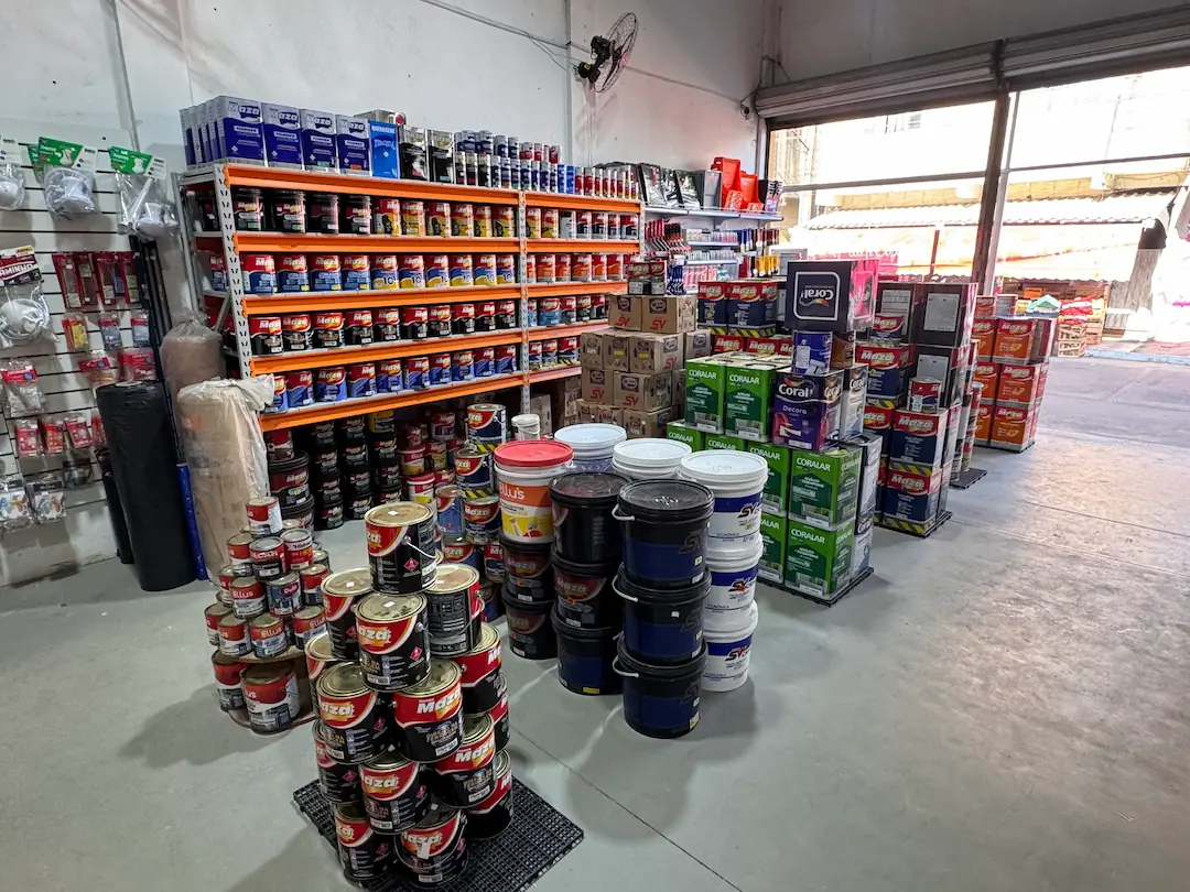 Interior da loja FGL Instalações com prateleiras de tintas Maza, Coral e SV